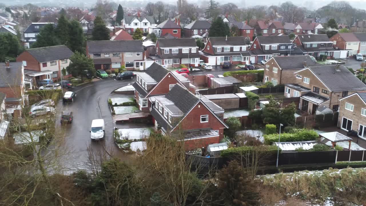 Snedækket luftfoto af et beboelseskvarter i en landsby, vinterfrosne huse og veje i nordvest, langsom kamerakørsel mod højre