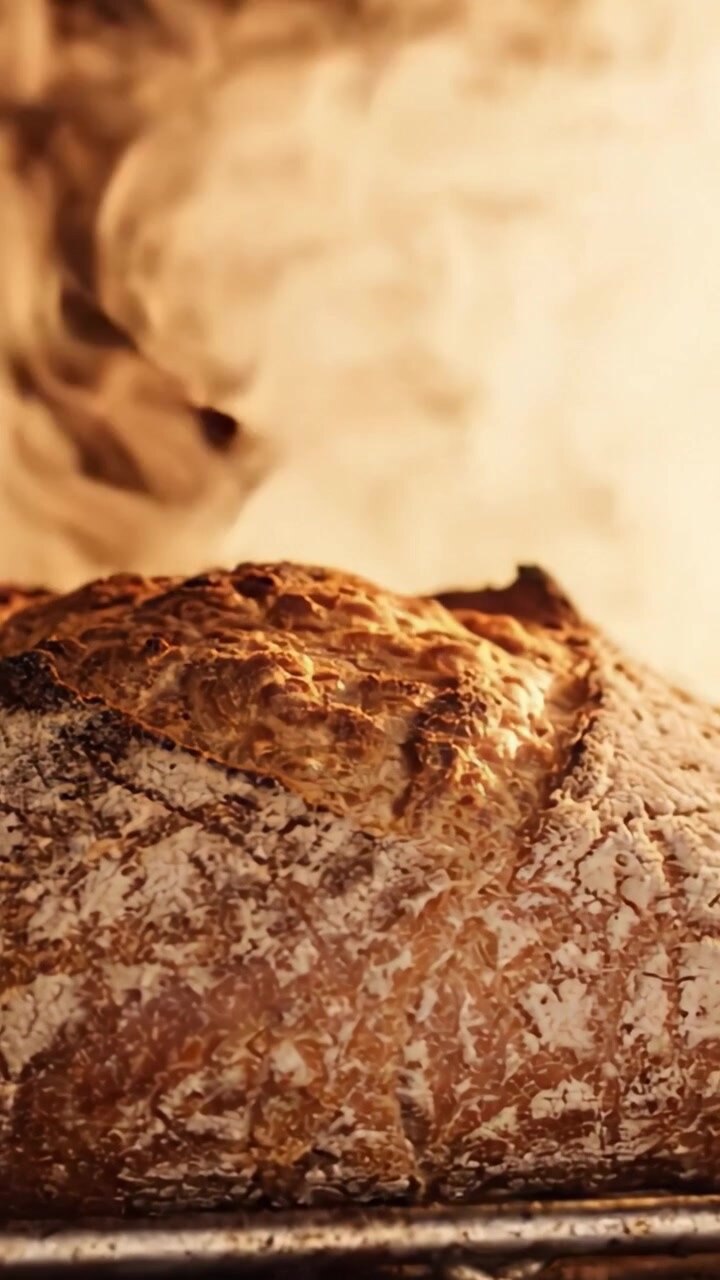Artisan Bread Baking to Perfection: Capturing the Beauty and Texture of Freshly Baked Loaf in a Warm Oven Environment with a Steaming Atmosphere