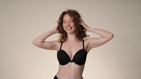 smiling caucasian red head woman dancing in underwear in the studio