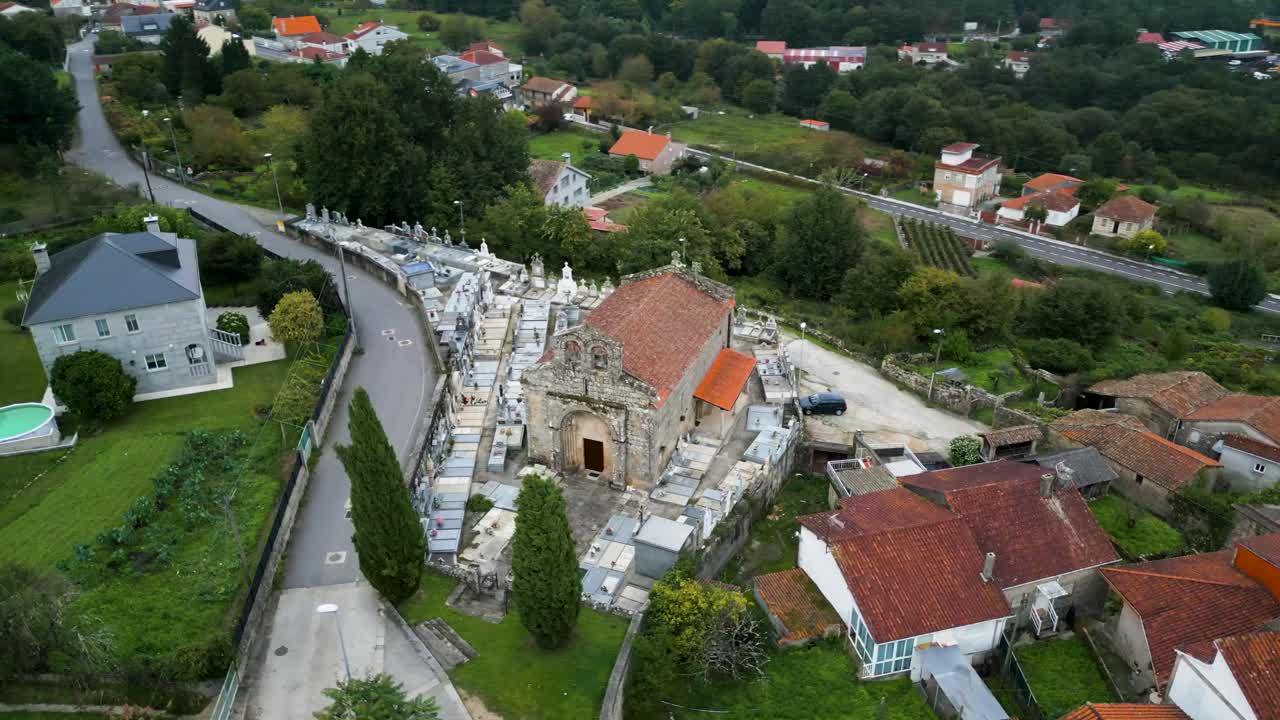 High angle aerial orbit view of Santiago de Gustei church and rural village landscape in Galicia, Spain