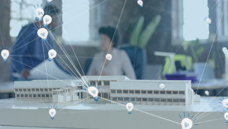 animation of lightbulb icons over diverse colleagues discussing with model in office