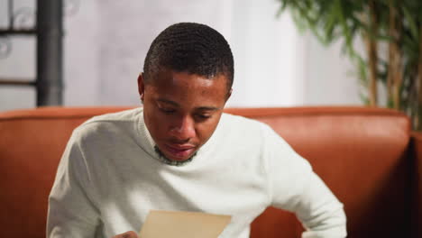 Confused-guy-looks-at-old-picture-of-family-member-with-pity