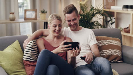 una joven pareja viendo videos en un teléfono celular