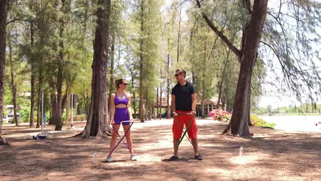 couple workout with resistance bands in a park