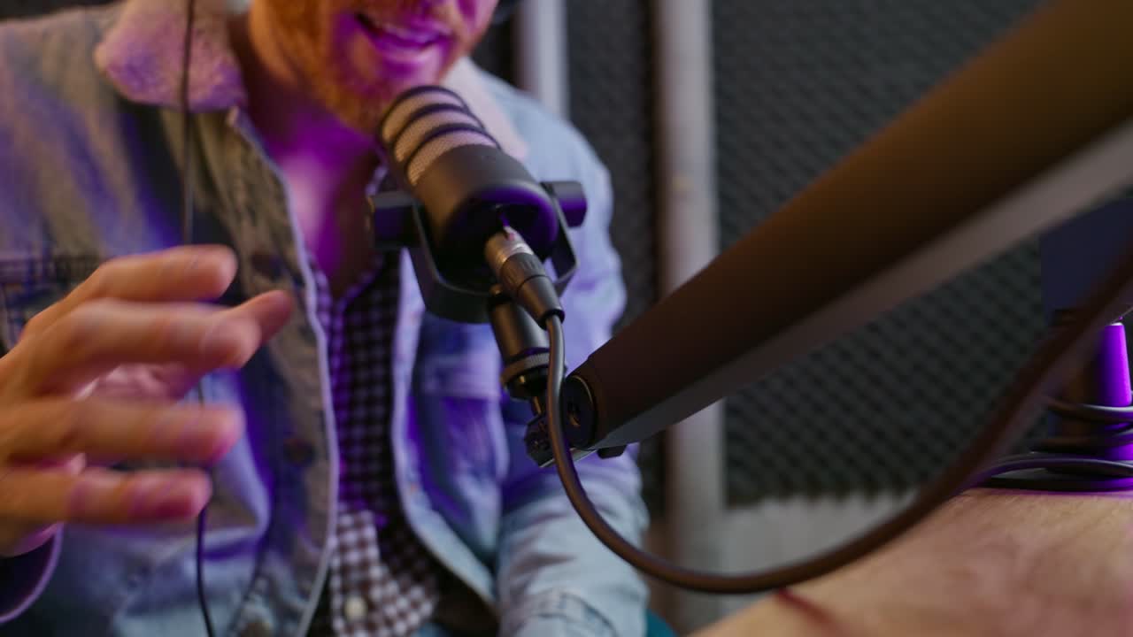 Close up on headphones hanging on mic stand in radio or podcast sound studio as host or guest picks them up and sets up microphone for recording voice or talking on professional live streaming show
