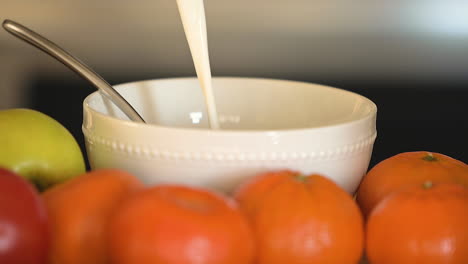 pouring milk into breakfast bowl