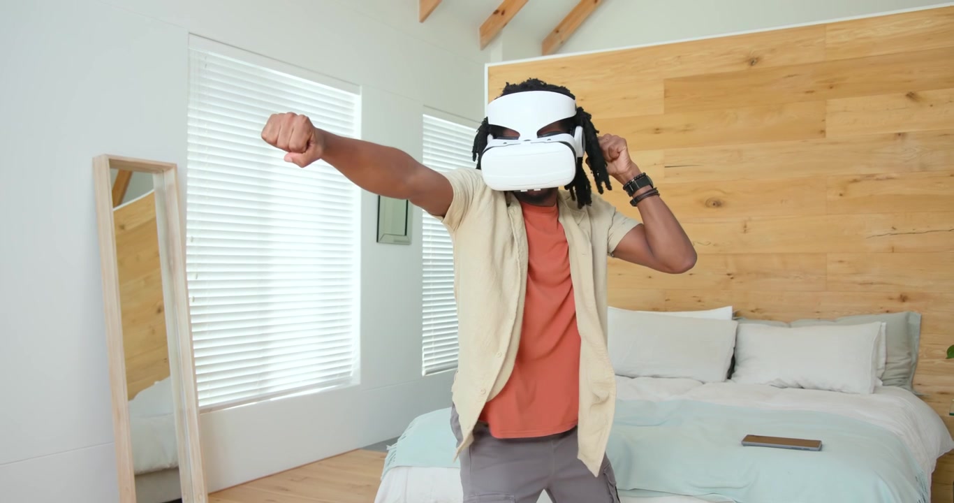 Uomo che indossa un visore VR bianco che sferra pugni, si muove e lo aggiusta in camera da letto seguendo il gioco