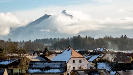 timelapse of a mountain with clouds building up looking over the village of radovljica in slovenia