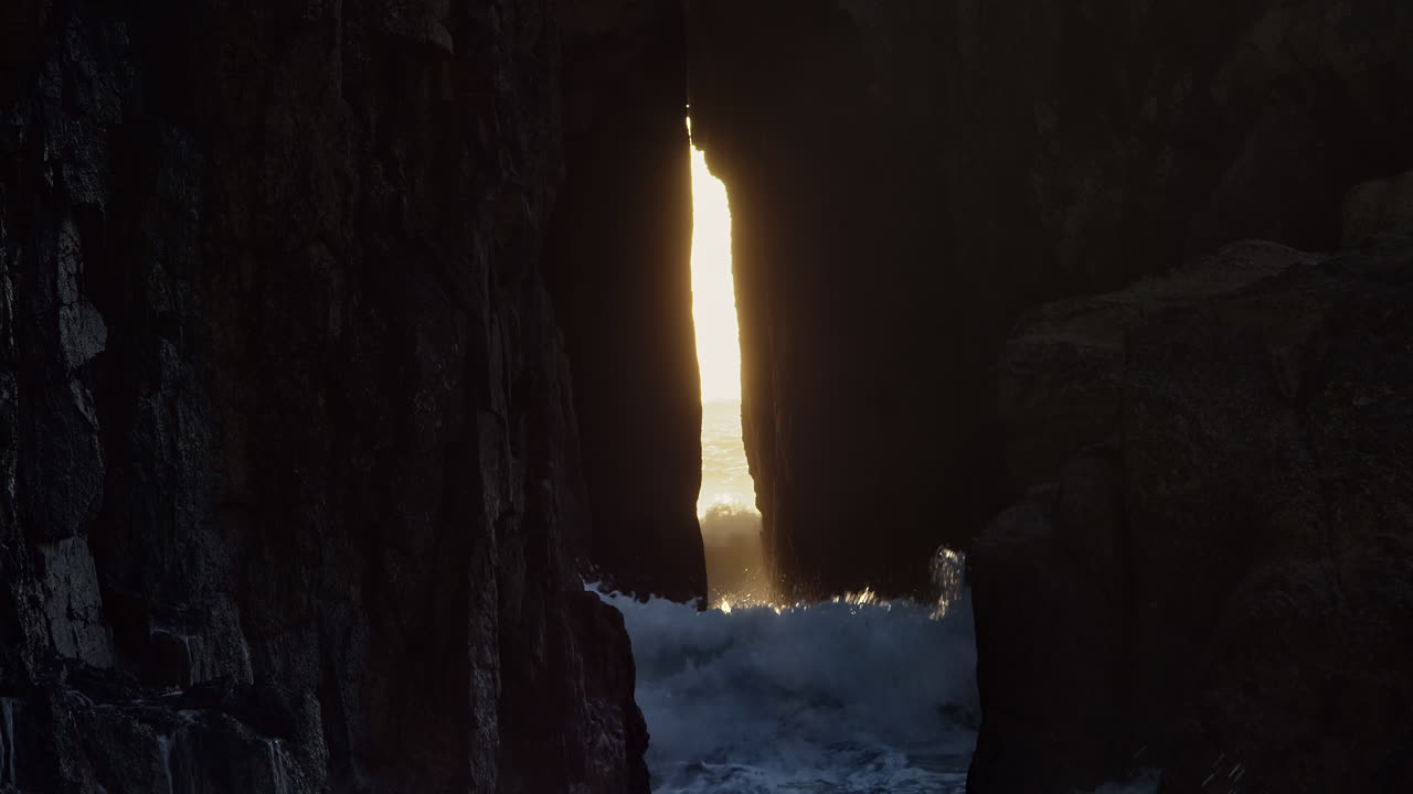 olas oceánicas rompiendo contra el arco de roca zawn pyg en la playa de nanjizal, cornualles, reino unido