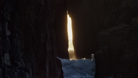 olas oceánicas rompiendo contra el arco de roca zawn pyg en la playa de nanjizal, cornualles, reino unido