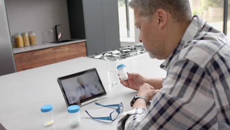 senior biracial male patient and doctor having video call on tablet, slow motion