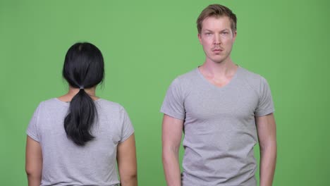 young multi-ethnic couple turning and crossing arms together