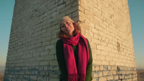 woman by an old brick building at sunrise