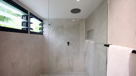 Modern-Grey-tile-ensuite-bathroom-with-white-and-black-vanity,-glass-shower-screen-and-modern-rond-mirror