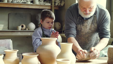 grandfather and grandson working on pottery