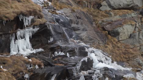 Wind-Weht-über-Zerklüfteten-Berghang-Und-Drückt-Kaskadierendes-Wasser-Seitwärts