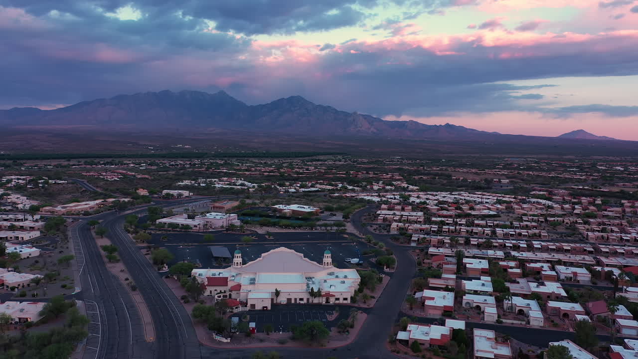 Drone sorvola la comunità di Desert Hills a Green Valley, Arizona, durante un tramonto intenso con nuvole - ripresa aerea