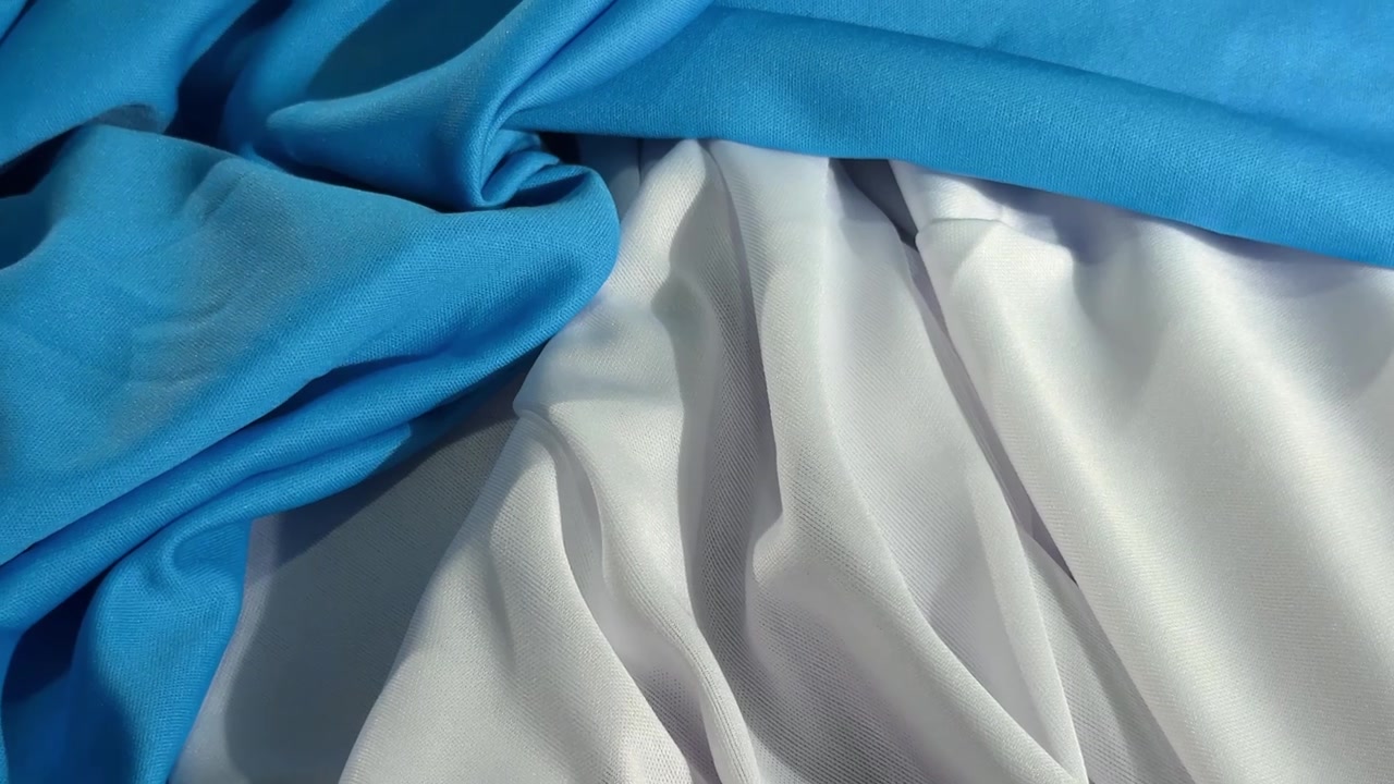ผ้าสีขาวและสีน้ำเงินที่พาดเป็นรอยพับอ่อนนุ่ม