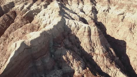 drone-shot-flying-over-while-camera-slowly-tilts-up-over-a-desert,-moonlike-landscape-somewhere-in-the-West-USA-in-4k