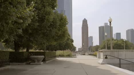 Schieben-Sie-An-Einem-Schönen-Sommertag-Langsam-Den-Bürgersteig-Entlang,-Vorbei-An-Bäumen-In-Richtung-Gebäude-In-Chicago