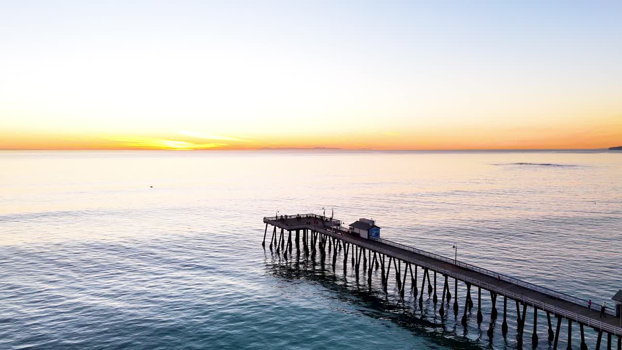 Aerial View of southern california pier with a beautful orange sunset