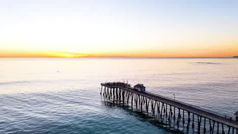 Luftaufnahme-Des-Piers-In-Südkalifornien-Mit-Einem-Wunderschönen-Orangefarbenen-Sonnenuntergang