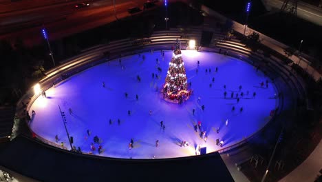 pista de patinaje sobre hielo por la noche con árbol de navidad