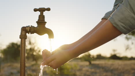 Frauenhände-Fangen-Wasser-Unter-Leitungswasser-Auf-Durstiger-Bauer-Trinkt-Süßwasser,-Das-Bei-Sonnenuntergang-Aus-Dem-Wasserhahn-Fließt,-Spart-Wasserkonzept