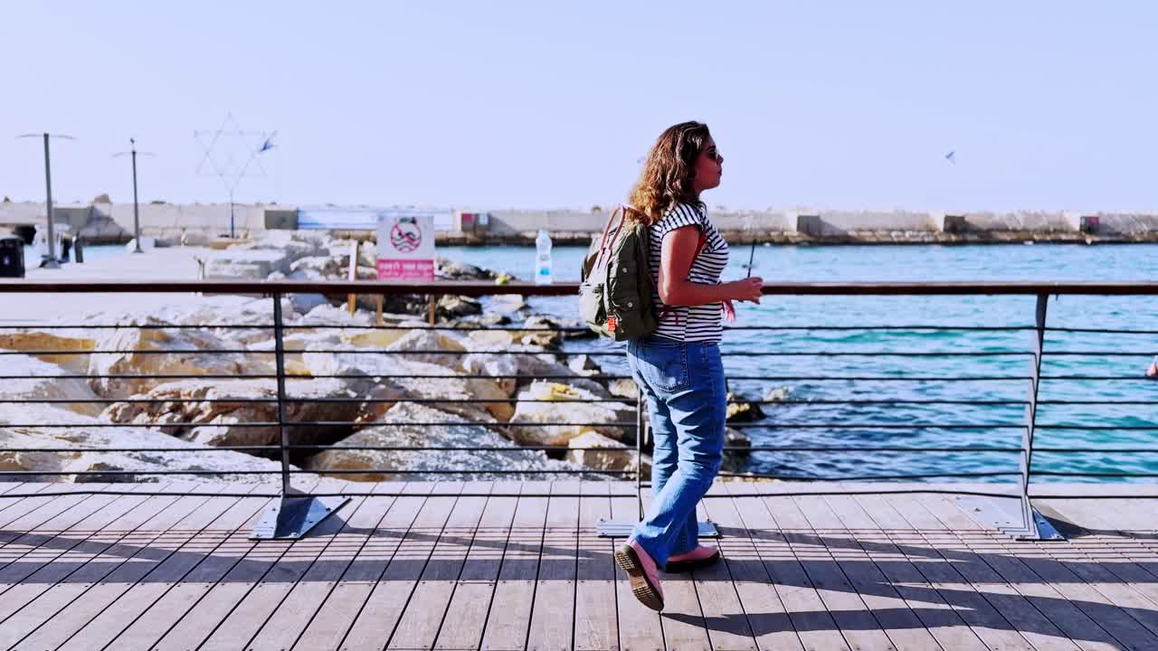 Viaggiatrice con bevanda fresca in una giornata di sole a Jaffa