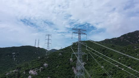 imágenes aéreas de drones de torres de transmisión de energía de alto voltaje con pilares de línea en áreas montañosas para distribuir electricidad - paisaje natural y concepto industrial para el desarrollo sostenible