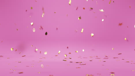 cae confeti dorado en el suelo del fondo del estudio rosa