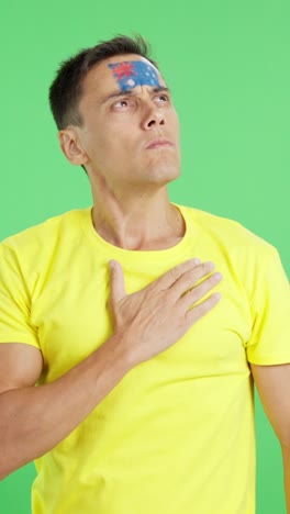 man listening to the australia national anthem with solemnity