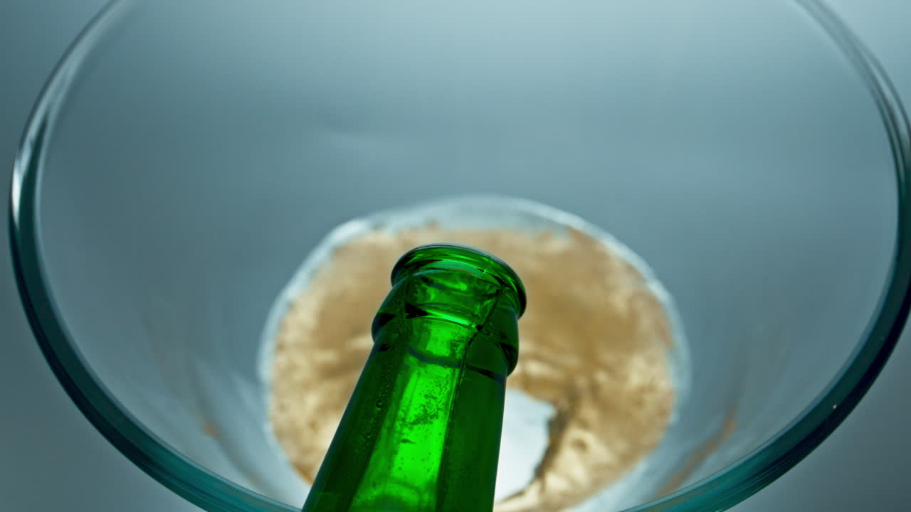vaso de vertido de cerveza lager embotellado de primer plano. vaso de llenado de bebidas frías espumosas