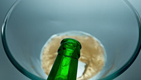 bottled lager beer pouring vessel closeup. sparkling cold beverage filling glass