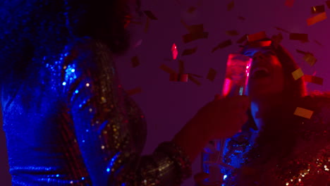 Close-Up-Of-Two-Women-In-Nightclub-Bar-Or-Disco-Dancing-And-Drinking-Alcohol-With-Paper-Confetti-2