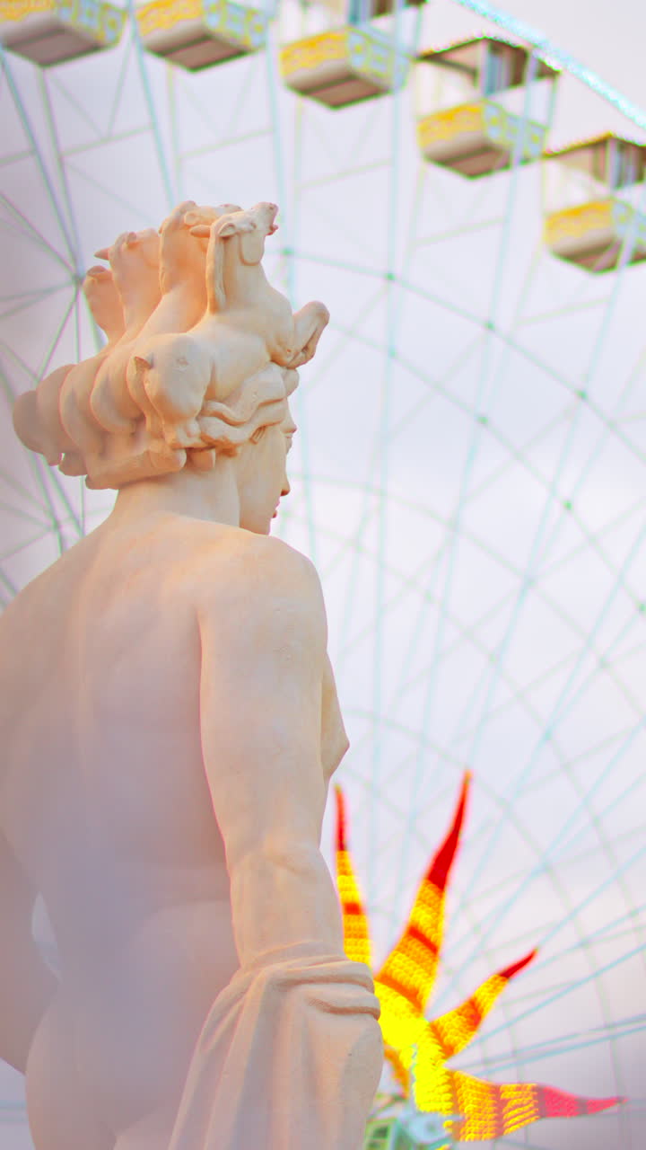 Nice, France - December 8, 2024: Apollo statue in the Fontaine du Soleil at Place Massena with a ferris wheel on the background. Vertical