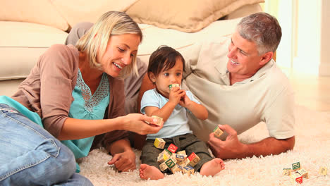 Father-and-mother-playing-with-baby-on-carpet