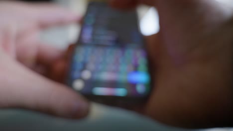 Blurry-close-up-view-of-caucasian-hands-using-smartphone-to-send-text-message