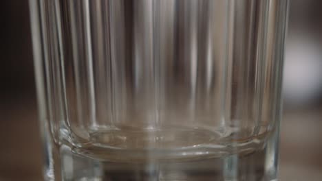 instant powdered coffee scooped into transparent glass, shallow focus close-up, slowmo