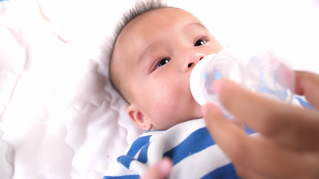 Mother Gives To Drink Water Baby From Bottle, Video In 4K