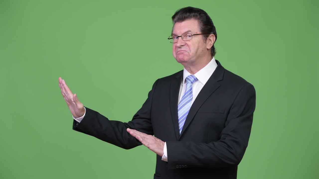Senior handsome businessman gesturing stop to the side