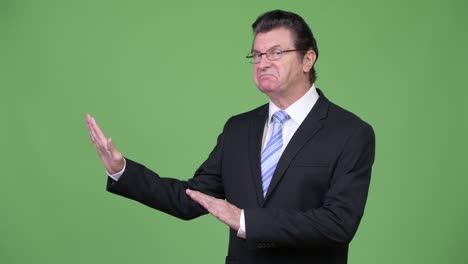 senior handsome businessman gesturing stop to the side