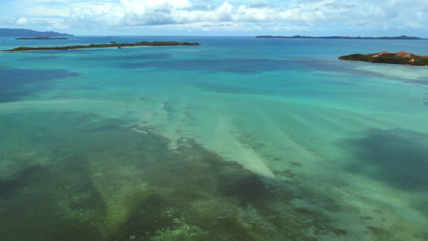 Sweeping-aerial-panning-shot-of-small-islands-near-Boat-Pass,-New-Caledonia