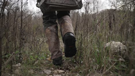 hunter walking through thick brush to a deer stand