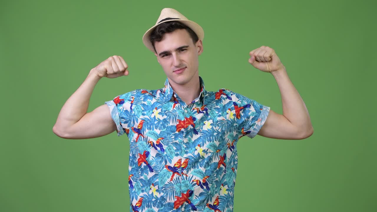 Young handsome tourist man flexing muscles