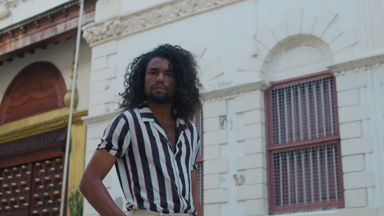 Uomo di colore elegante e alla moda cammina per le strade del centro storico.