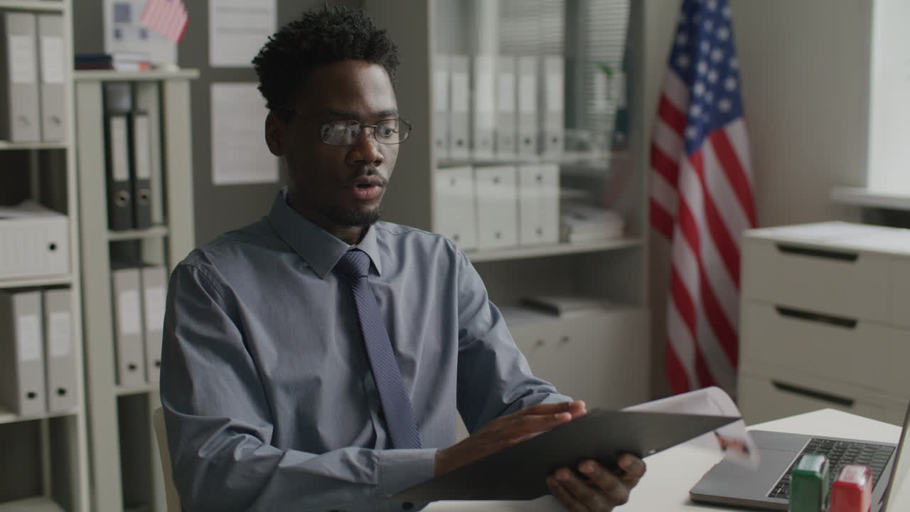 African American Visa Officer Interviewing Applicant at US Embassy