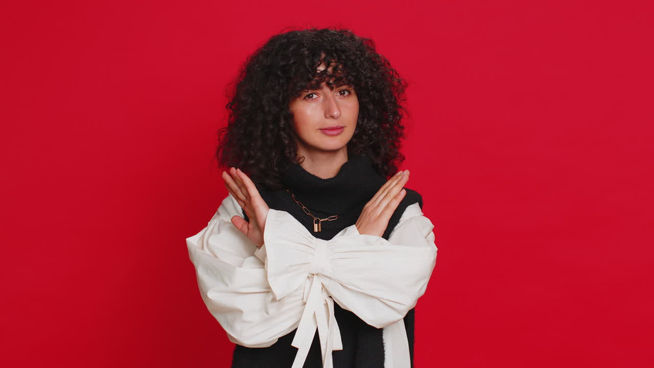 Woman says no hold palm folded crossed hands in stop gesture warning of finish prohibited access