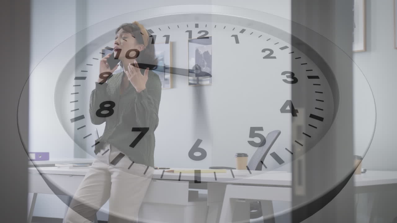 анимация тикающих часов против азиатской женщины, разговаривающей на смартфоне в офисе