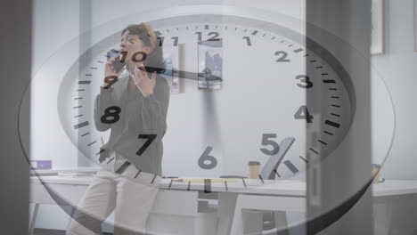 animation of ticking clock against asian woman talking on smartphone at office